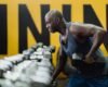 Strength training for older adults: senior man lifting dumbbells in a gym